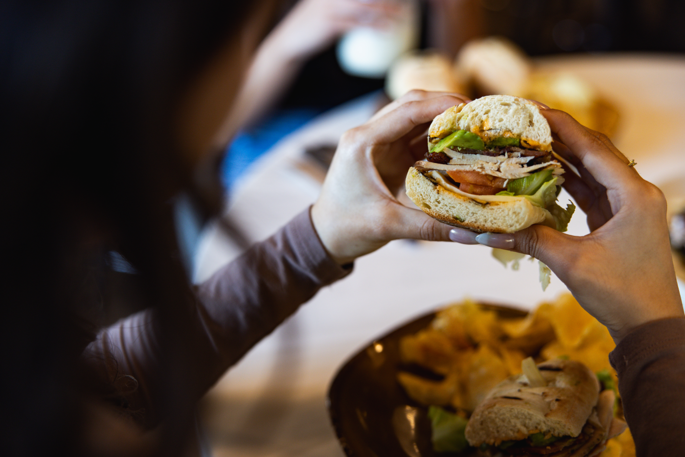 Happy woman holding Urban Plates sandwich